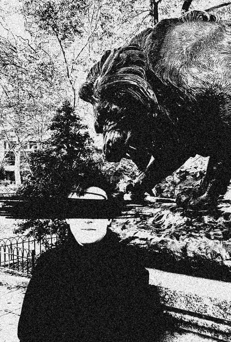 Simon Donoway beside a lion statue, eyes blacked out